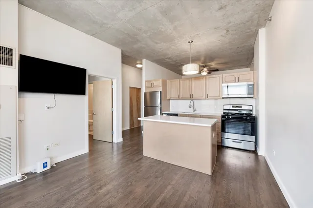 a kitchen with a refrigerator and a stove top oven