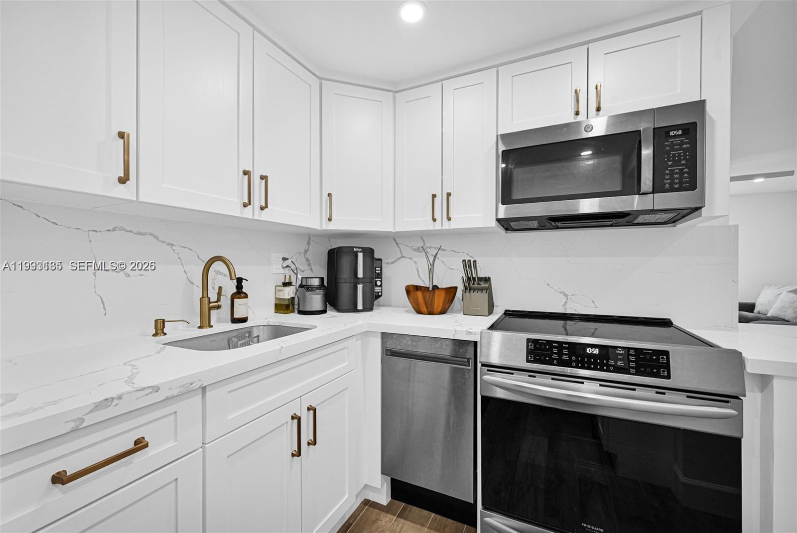 8609 Southwest 68th Court, Unit 24 Pinecrest, FL 33156 - Photo 13 of 39 a kitchen with white cabinets and stainless steel appliances