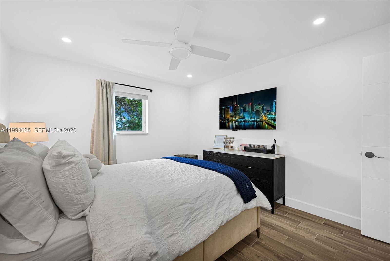 8609 Southwest 68th Court, Unit 24 Pinecrest, FL 33156 - Photo 25 of 39 a bedroom with a bed and wooden floor
