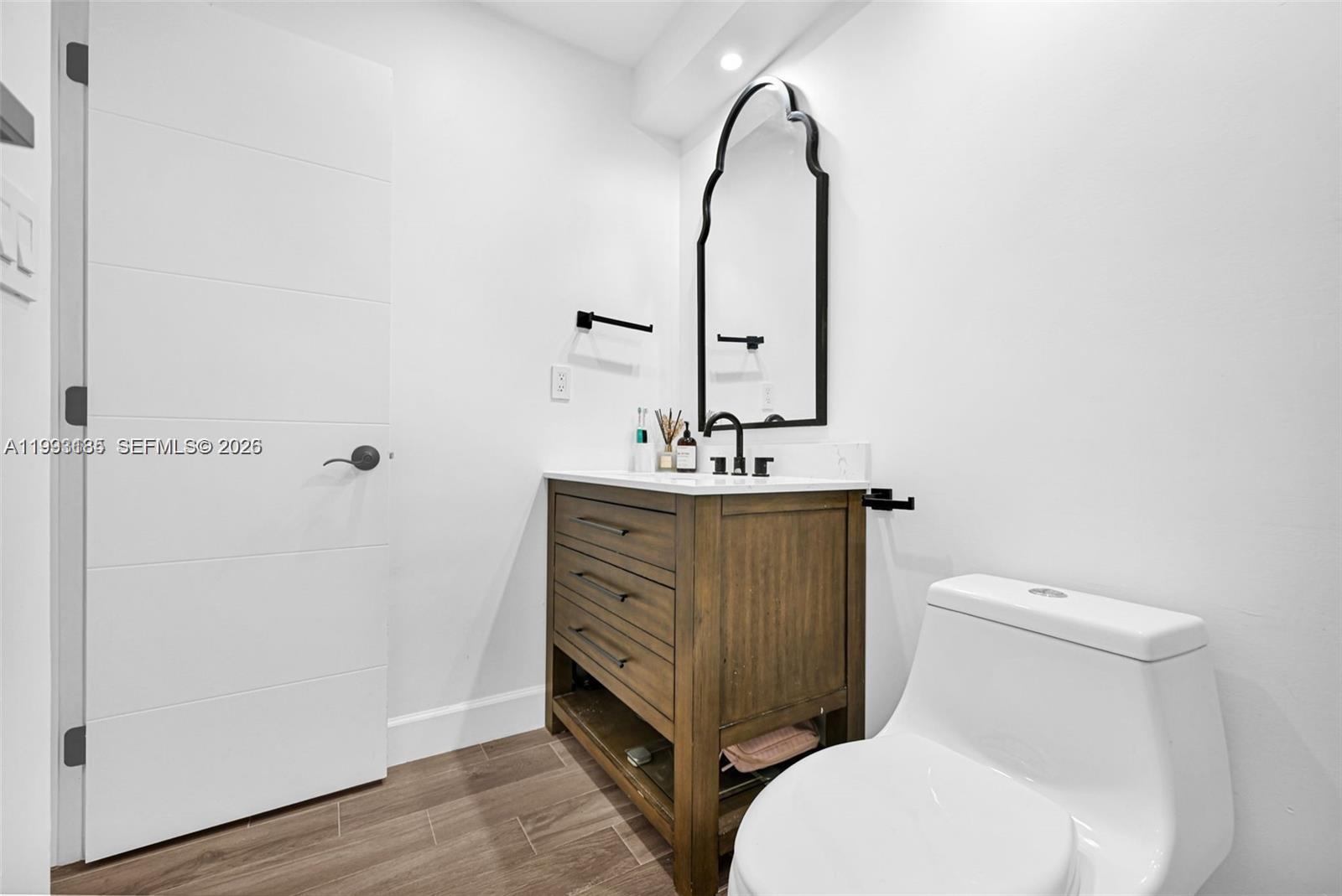 8609 Southwest 68th Court, Unit 24 Pinecrest, FL 33156 - Photo 27 of 39 a bathroom with a toilet sink and mirror