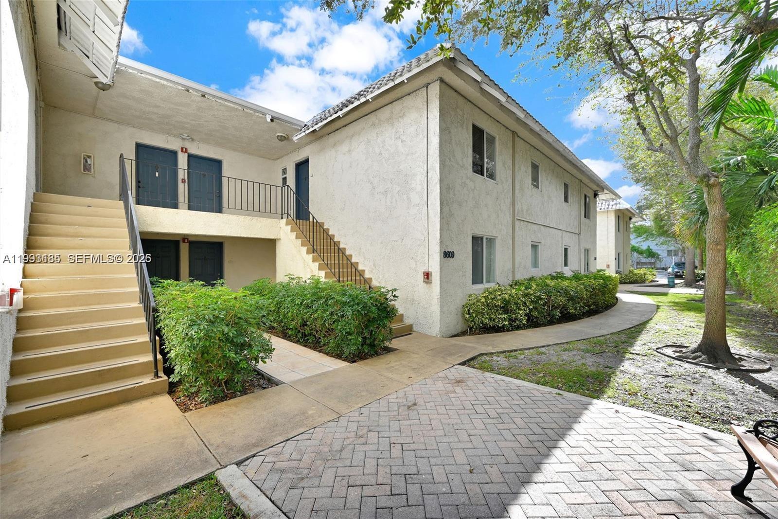 8609 Southwest 68th Court, Unit 24 Pinecrest, FL 33156 - Photo 4 of 39 a front view of a house with garden