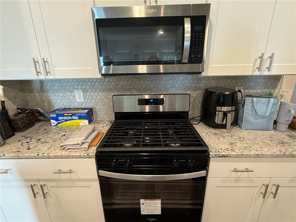 2496 Rocky City Lane Snellville, GA 30078 - Photo 14 of 15 a kitchen with granite countertop cabinets stove and microwave