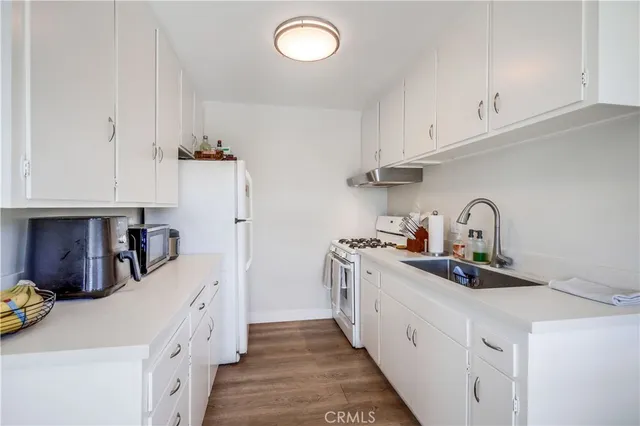 a kitchen with sink a stove and cabinets