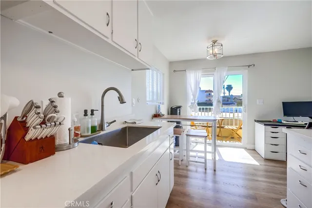 a large kitchen with a stove a sink a refrigerator and a view of living room
