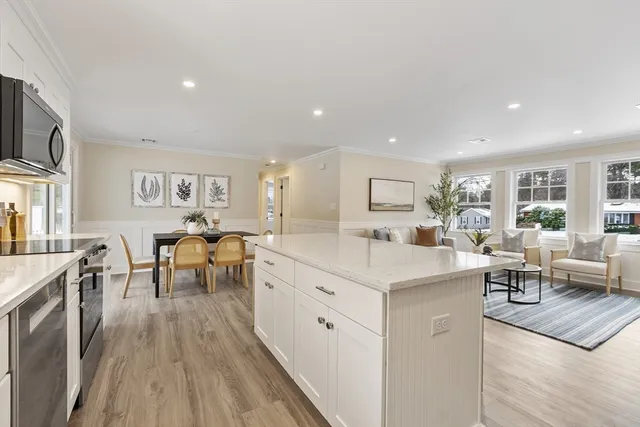 a large white dining hall with stainless steel appliances granite countertop lots of counter top and couches