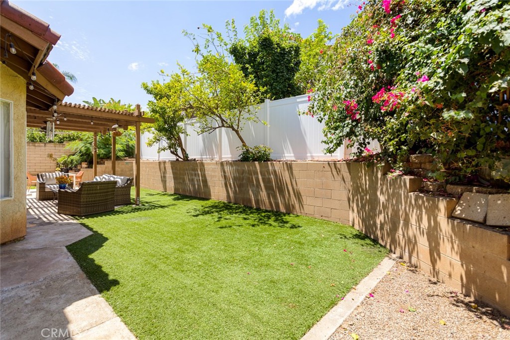 1942 Silverwood Circle Corona, CA 92881 - Photo 5 of 24 a backyard of a house with table and chairs and a large tree
