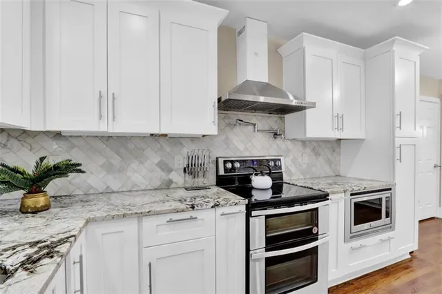 a kitchen with stainless steel appliances white cabinets and a stove a sink