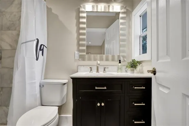 a bathroom with a sink vanity mirror and toilet