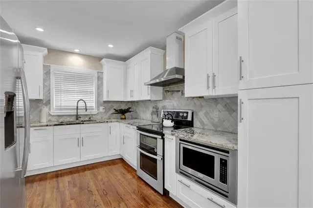 a kitchen with stainless steel appliances granite countertop a stove a sink and a microwave