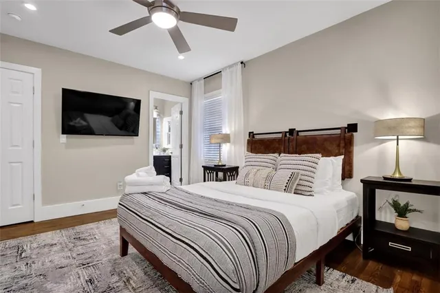 a bedroom with a bed a flat screen tv and a chandelier