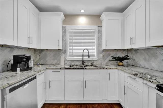 a kitchen with granite countertop white cabinets and white appliances