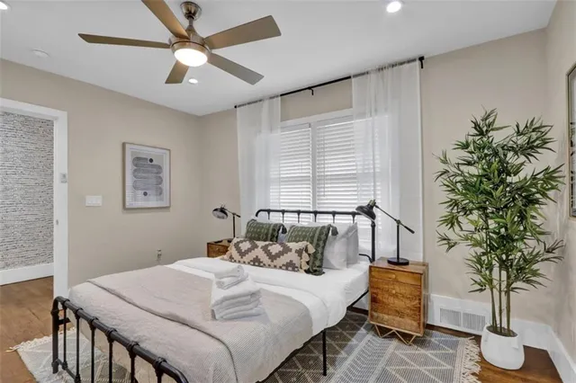 a bedroom with a large bed and a potted plant