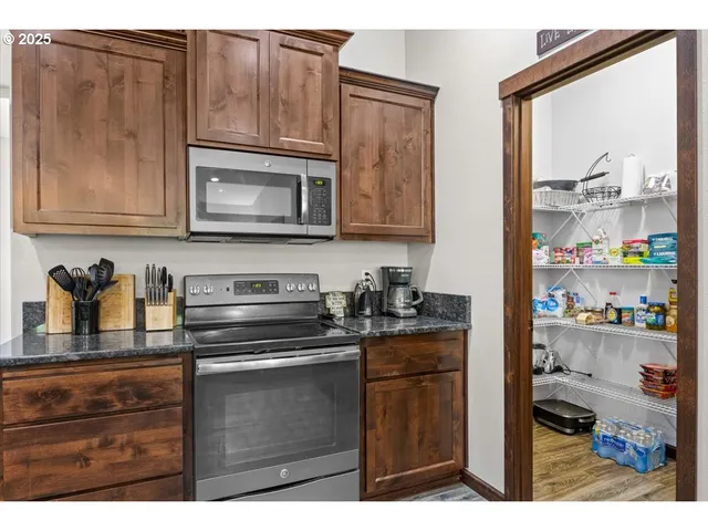a kitchen with granite countertop cabinets stainless steel appliances and a counter space