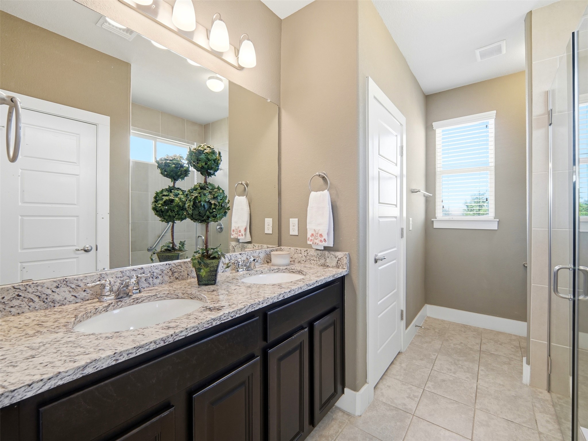 6916 Cardinal Bloom Loop Austin, TX 78744 - Photo 12 of 37 a bathroom with a granite countertop sink and a mirror