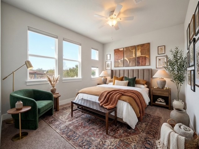 6916 Cardinal Bloom Loop Austin, TX 78744 - Photo 19 of 37 a spacious bedroom with a bed a couch and a window