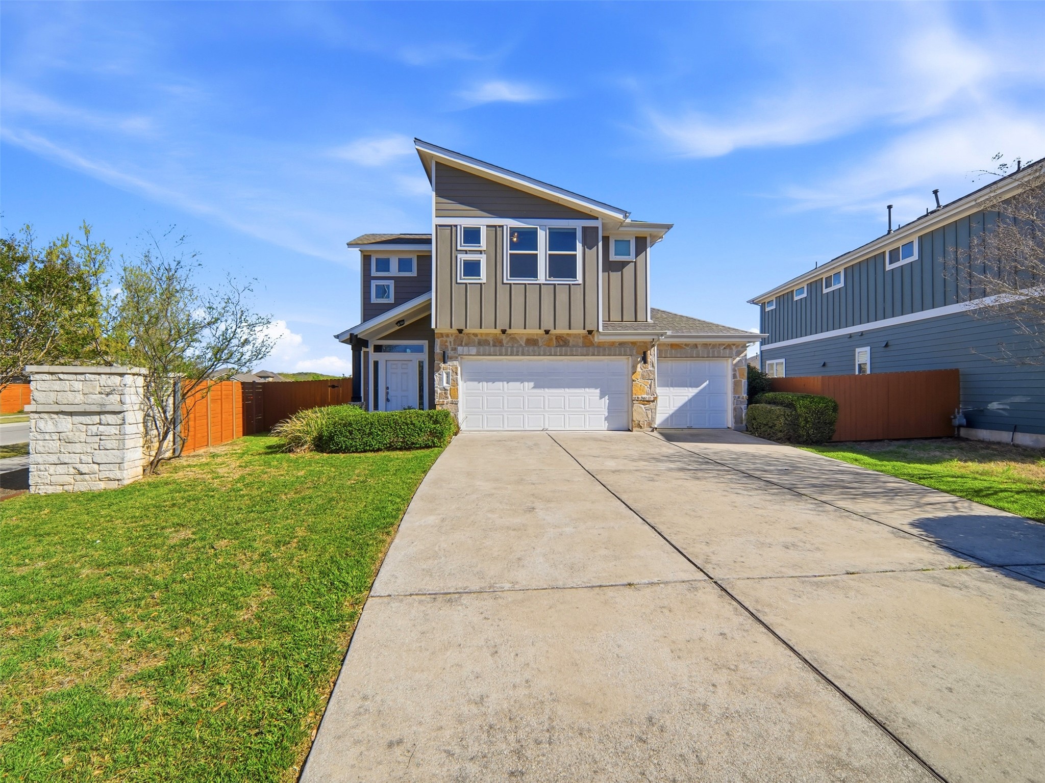 6916 Cardinal Bloom Loop Austin, TX 78744 - Photo 2 of 37 a front view of a house with a yard and a garage