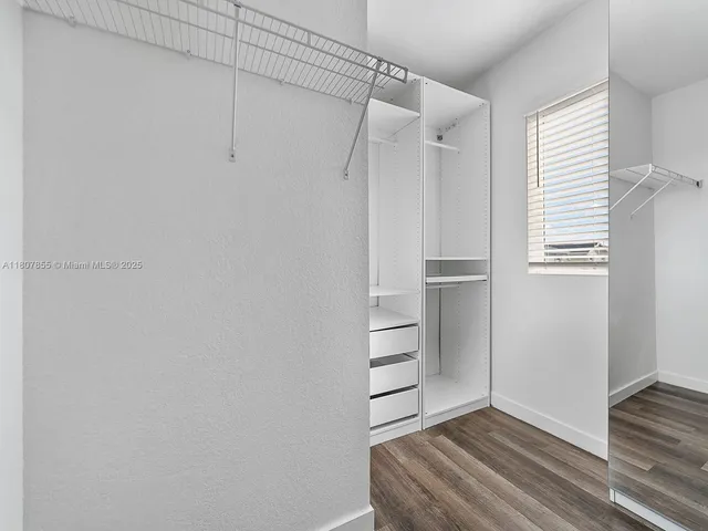 a view of walk in closet with empty racks