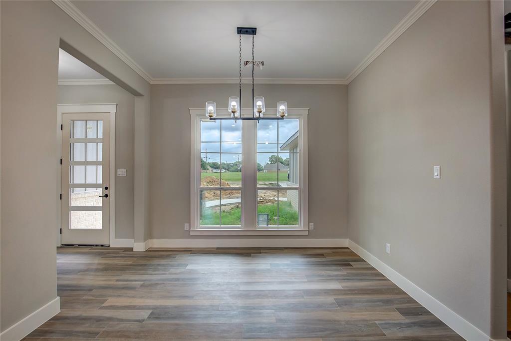 405 Door Key Ranch Road Trinidad, TX 75163 - Photo 11 of 28 Unfurnished dining area featuring ornamental molding, an inviting chandelier, and wood-type flooring