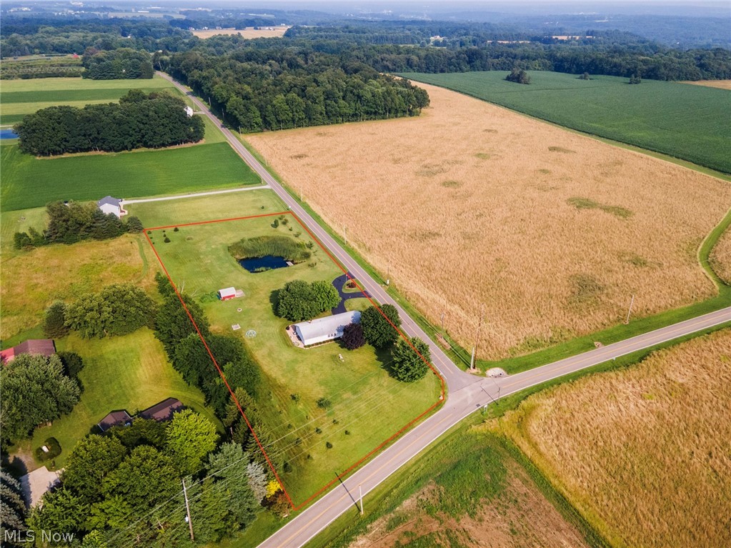 8360 Roller Road Salem, OH 44460 - Photo 10 of 45 Aerial perspective highlighting a property with a distinct pond, surrounded by expansive green spaces and wooded areas. Property lines are not exact.