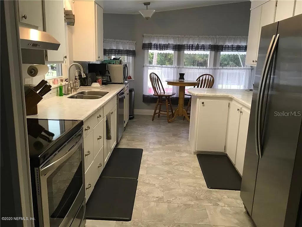 133 Bayou Drive Satsuma, FL 32189 - Photo 12 of 30 a kitchen with sink refrigerator and cabinets