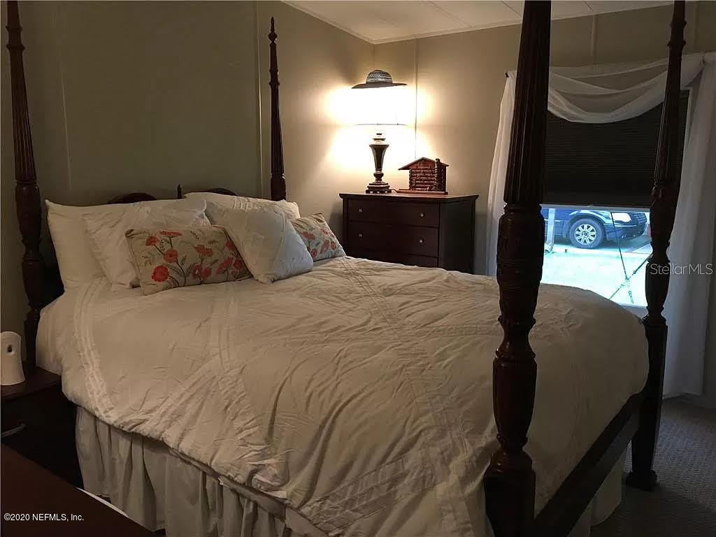 133 Bayou Drive Satsuma, FL 32189 - Photo 13 of 30 a bed sitting in a bedroom next to a lamp