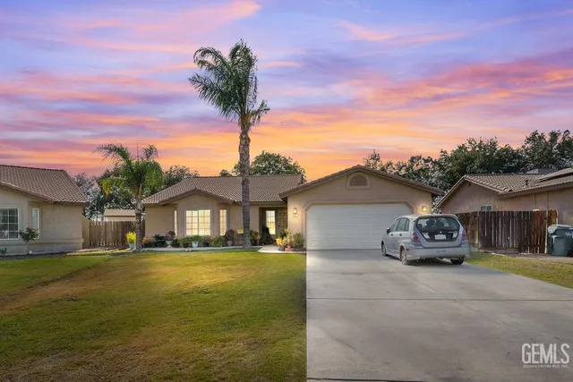 a front view of a house with a garden and lake view
