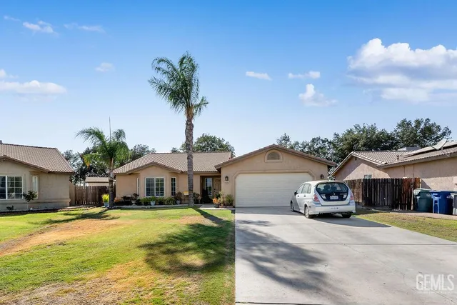 a front view of a house with a garden and mountain view