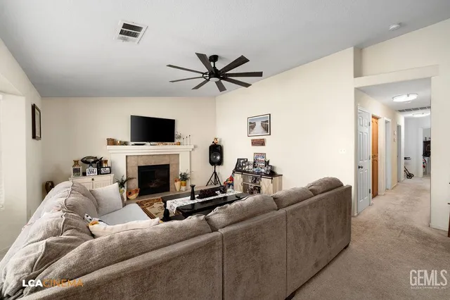 a living room with furniture a fireplace and a flat screen tv