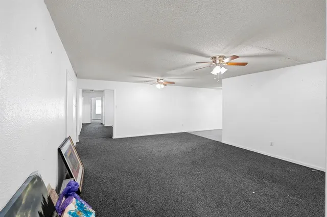 an empty room with a chandelier fan and closet