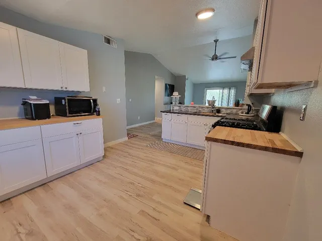 a kitchen with granite countertop a sink and a stove top oven