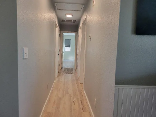 a view of a hallway with wooden floor