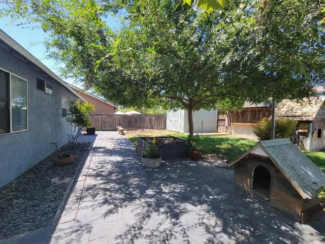 a view of a backyard with table and chairs under an umbrella