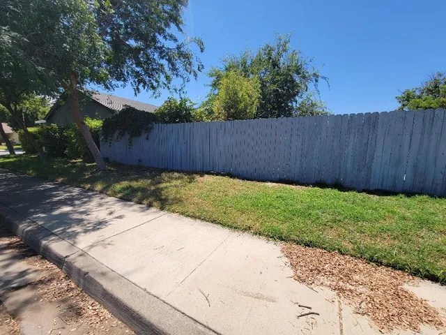 a view of backyard with wooden fence