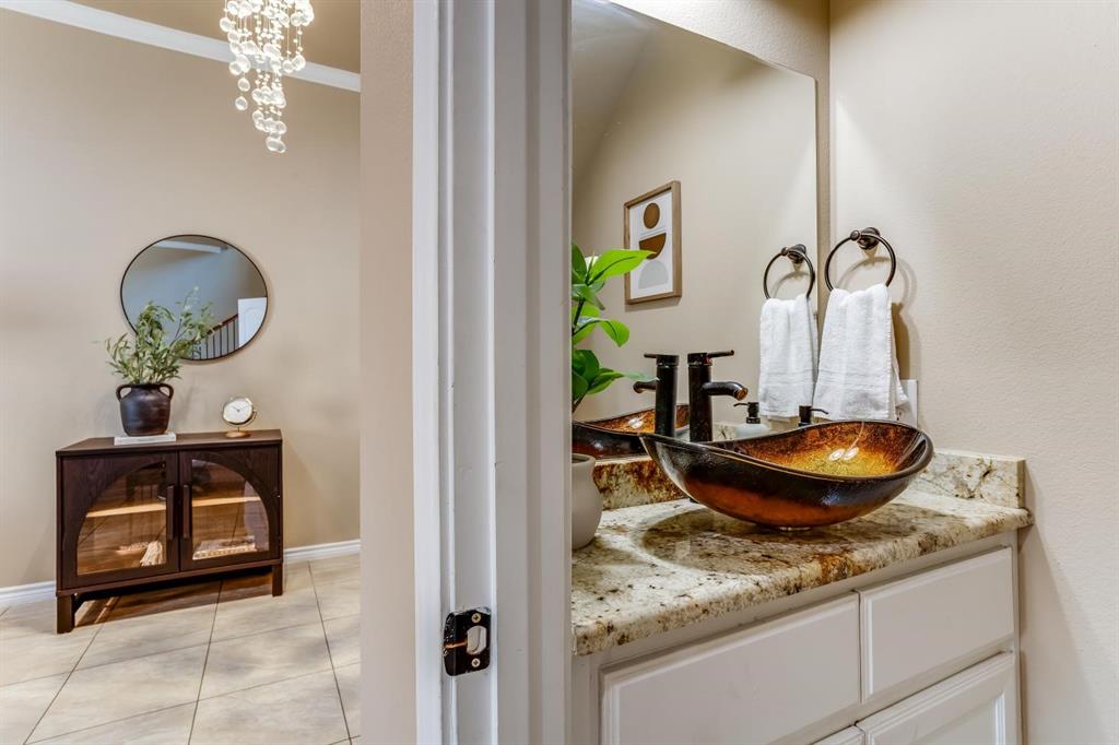 12364 Halima Street Dallas, TX 75243 - Photo 27 of 30 Powder room with a vessel sink, dark bronze fixtures, and a vanity with a light-colored countertop