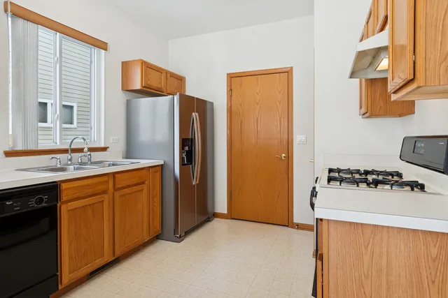 a kitchen with stainless steel appliances granite countertop a refrigerator and a sink