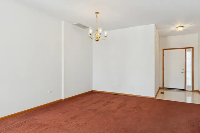 an empty room with a chandelier fan