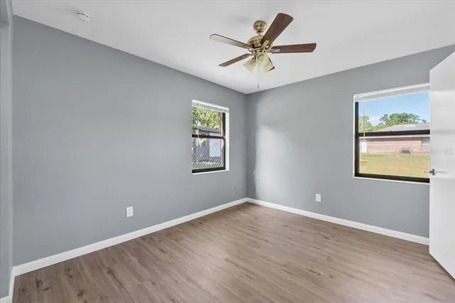 a view of a big room with wooden floor and windows