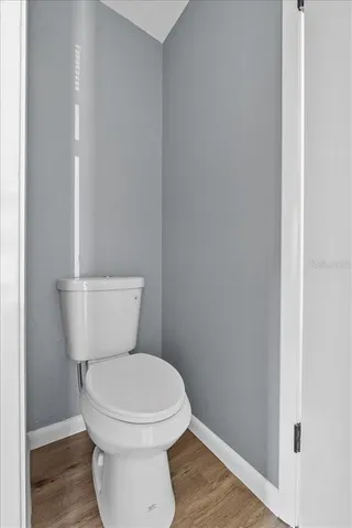 a white toilet sitting next to a wooden cabinet