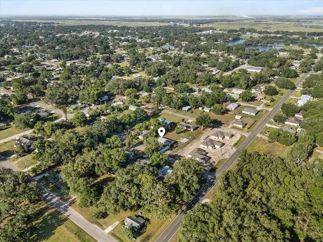 an aerial view of residential houses with outdoor space and trees