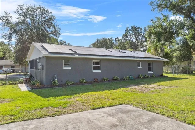 a view of a yard in front of a house with large tree