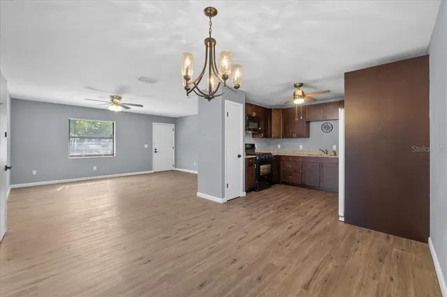 a view of a kitchen with a sink dishwasher stove and wooden floor