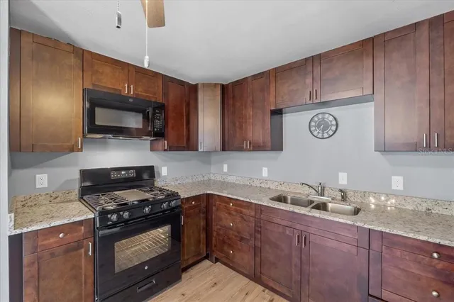 a kitchen with stainless steel appliances wooden cabinets and a stove top oven