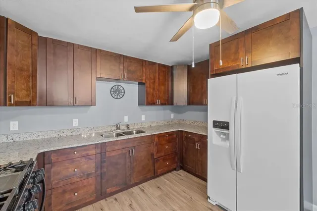 a kitchen with a sink a refrigerator and cabinets