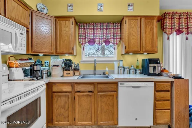 a kitchen with stainless steel appliances a sink cabinets and a window