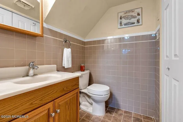 a bathroom with a sink mirror vanity and toilet