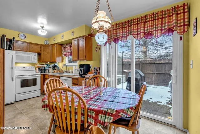 a very nice looking dining room with wooden floor and a chandelier