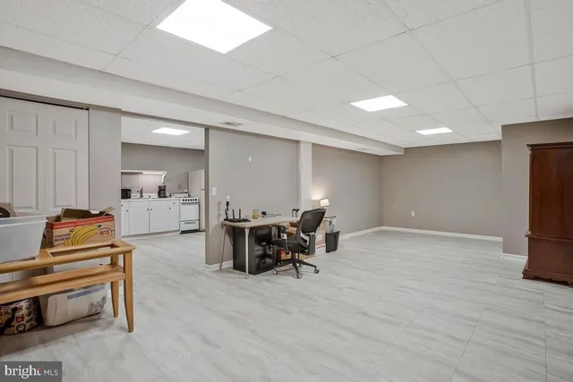 a view of a kitchen with refrigerator and white cabinets