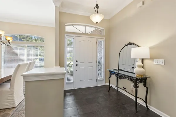 a dining room with furniture a chandelier and wooden floor