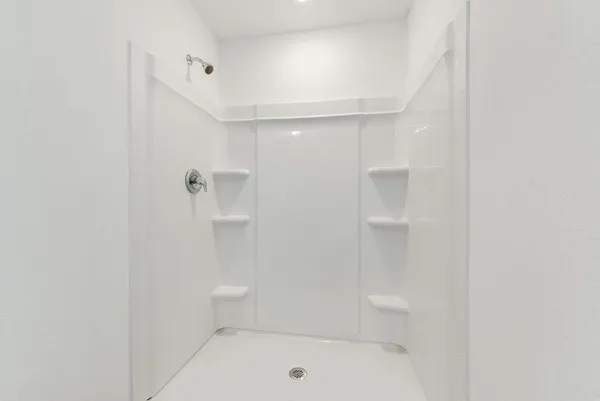 a bathroom with a toilet a sink a mirror and a shower