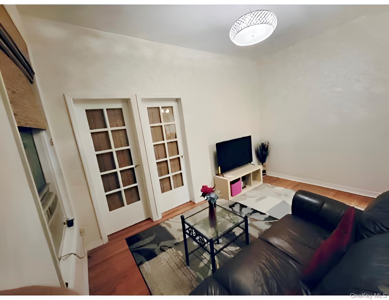 324 East 50th Street, Unit 3A Manhattan, NY 10022 - Photo 6 of 13 a living room with furniture and a flat screen tv